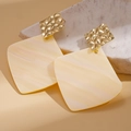 Macro detail of geometric acrylic earrings with gold hammered texture on warm background - Silver Earring Post - Beige Rhombus