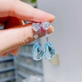 Dettaglio di orecchini pendenti con cristallo azzurro a goccia e zirconi bianchi lucidi - Base Argentata / Acqua