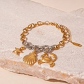 Detailed close-up of gold sea star, shell and crab charms on a bicolor metal chain - Gold Titanium Steel Starfish Crab Spliced Bracelet