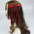 Elegant red polyester ribbon bow hair clip with double streamers worn by a model - Burgundy