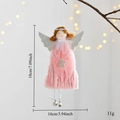 Vista dettagliata di un angelo di peluche rosa con ali d'argento e campanelli per l'albero - Rosa