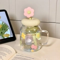 Floral glass mason jar with handle, beige lid, and cute flower straw topper on desk - Green