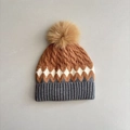 Macro detail of tricolor diamond knit pattern and fluffy pompom on winter toddler hat - 2-5 Years Old / Brown