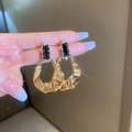 Dettaglio di orecchini dorati con pietre preziose scure e grandi cerchi plissettati - Orecchini a Goccia Plissettati a Goccia d'Acqua Irregolari Dorati (Perno in Argento 925)