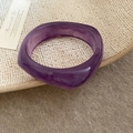Detail view of purple resin bangle with wavy geometric profile on beige woven tray - Purple Quicksand Marble