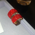 Primo piano di orecchini a C con cristalli rossi su un astuccio per gioielli in velluto - Stile con Ago in Argento S925 / Rosso