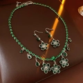 Détail d'une parure de trèfles de luxe avec fleurs en zircon vert et pendentifs goutte - Vert