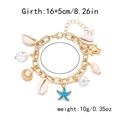 Dettaglio di un bracciale boho dorato con ciondoli a conchiglia, stella marina e perle su fondo bianco - Braccialetto BR25Y0186