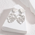 Silver hollow monstera leaf earrings with heart studs on white geometric blocks - Silver Heart Monstera Leaf Drop Earrings (E941-01-AX)