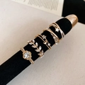 Dettaglio di un set di cinque anelli dorati con perle e zirconi su velluto nero - Set da 5 pezzi / Oro
