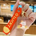 Lucky Cat acrylic keychain with golden sand and red Lucky strap in hand - New Year Lucky Cat - Blessing / Individual Packaging