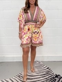 Detail of bohemian floral romper featuring deep V-neck, flared sleeves and high elastic waist - Pink