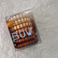 Detail of 4 gradient color spiral hair ties in transparent box with BOW rainbow logo - Brown
