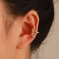 Makroaufnahme einer goldenen Schlangen-Ohrmanschette mit Diamanten am Ohr - Helles KC Gold Schlangenohrclip (Links 10190)