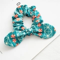 Blue velvet scrunchie with red star pattern and bow tie on a magazine background - Green Stars Velvet