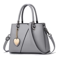 Light gray pebbled leather handbag with heart pendant and adjustable crossbody strap - Gray