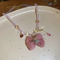 Detalle de collar de cuentas con lazo de felpa rosa, luna y extensión dorada - Collar de Lazo Grande de Cuentas Moradas / Rosa