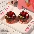 Detailliertes Makro von zwei Harz-Schokoladenkuchen-Miniaturen mit Sternen und Kirschen - Braun