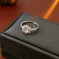 Dettaglio macro di anello a fiore argento con pietra grigia su trama nera - Aperto Regolabile / Fiore d'Argento