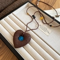 Dettaglio della collana bohémien con pendente a cuore e perla turchese in scatola portagioielli - Ciondolo a Cuore in Pietra Lavica Con Perlina Blu e Perline Marroni