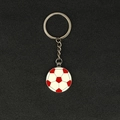 Red and white soccer ball keychain made of polished silver-colored metal on dark surface - Round Soccer/Yellow