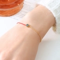 Red braided cord bracelet with half gold chain and dark circular stone on model's wrist - January Black