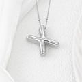 Macro shot of silver puffy X-shaped balloon letter pendant on a fine bead chain - Letter X Pendant