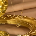Detail of gold double-ring pendant with CD cutout letters and star flower engraving - Gold CD Letter Double Ring Pendant