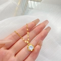 Collier en fleur dorée avec pendentif en zircon micro-pavé sur fond en maille blanche - Pétale de Zircone