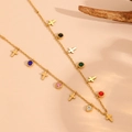 Dettaglio collana in oro con pietre preziose colorate e piccoli ciondoli a croce - Collana di Zirconi a Croce (T507)