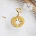 Golden round pendant with star cutout and spring clasp on white lace fabric background - Octagram Hollow Medallion