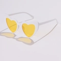 Detailansicht der herzförmigen Sonnenbrille mit weißem Rahmen und gelben Gläsern - Weißer Rahmen Gelbe Linsen