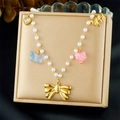 Close-up of pearl necklace with gold bow, pink heart, and blue butterfly charms - Bow Butterfly Zirconia Heart Style (N3742)