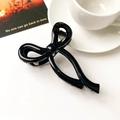 Close-up of a glossy black bow hair claw clip against a minimalist aesthetic background - Glossy Black