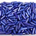 Macro-opname van blauwe lapis lazuli zeshoekige kristalpunten op een witte ondergrond - Lapis lazuli