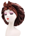 Detail of dark brown satin sleep bonnet with oversized bow and smooth glossy finish - Cross-Coffee