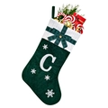 Detail of dark green velvet Christmas stocking with white embroidered letter C and bow - Green C