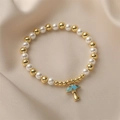 Perlenarmband aus Gold und Perlen mit blauem Pilzanhänger auf beigem Satinhintergrund - Blau