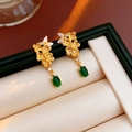 Dettaglio di orecchini vintage a fiore dorato con pietre preziose verdi in scatola - Oro con gemma verde (ago in argento S925)
