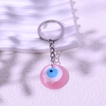 Rosa Evil Eye Schlüsselanhänger mit Silberring und Harzanhänger auf schlichtem Hintergrund - Rosa