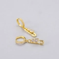 Detail of gold safety pin drop earrings with heart-shaped zircon stones on a grey background - Heart Safety Pin Earrings - Gold