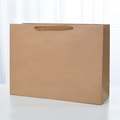 Heavyweight brown kraft paper gift bag with flat ribbon handles for boutique shopping - Oversized Horizontal Style