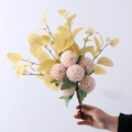 Artificial bouquet with pink pompon mums and yellow eucalyptus leaves held by hand - Champagne