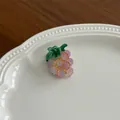 Vue détaillée d'une pince à cheveux en résine de raisin violet avec dégradé sur une assiette - Raisins