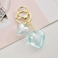 Détail d'un porte-clés doré avec deux pendentifs en forme de cœur effet iridescent - Bleu Ciel