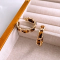 Close-up of golden metal and brown leopard print leather woven hoop earrings in jewelry box - 18# Dark Leopard Print Leather Woven Earrings (18#)