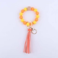 Détail de porte-clés en perles de silicone avec perle en hêtre et pompon à rayures oranges - Orange