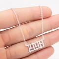 Detail view of silver 1998 birth year necklace pendant with dainty link chain - 1998 / Steel