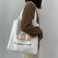 Détail d'un sac cabas blanc en toile avec lettrage et pendentif chat en peluche sur le côté - Blanc Chat
