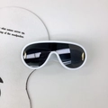 Détail de lunettes de soleil shield blanches avec accents métalliques dorés sur fond blanc - Cadre Blanc
